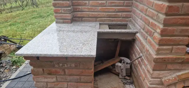 Siva granitna radna ploča na zidanom elementu vanjske kuhinje
