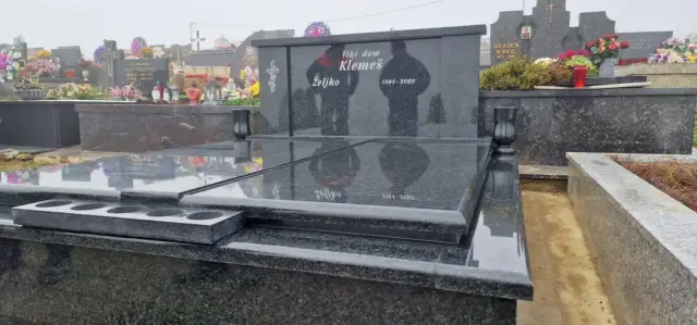Crni granitni grob s dvjema pločama i lampionima uz uzglavlje