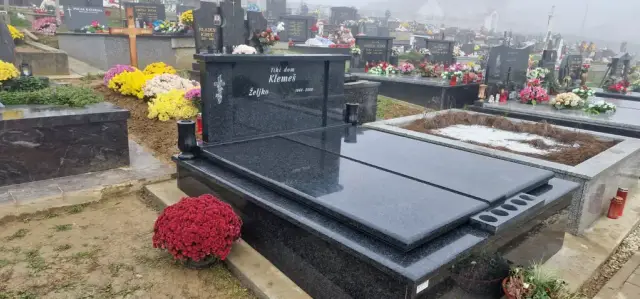Crni dvojni grob s držačem za lampione i crvenim krizantemama