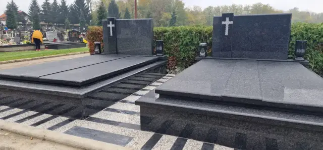 Dva tamnosiva dvojna groba s križevima i prugastim opločenjem