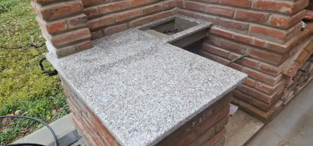 Kutna ploča od sivog granita s otvorom u vanjskoj kuhinji