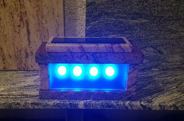 Pravokutni kameni grobni lampion s plavim osvjetljenjem na kamenoj podlozi