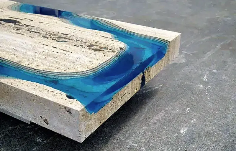 Detalj ruba stola od travertina s umetkom od plave prozirne smole